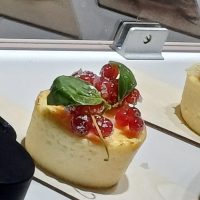 Postre individual con frutos rojos y albahaca