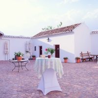Patio andaluz preparado para evento con mesas altas